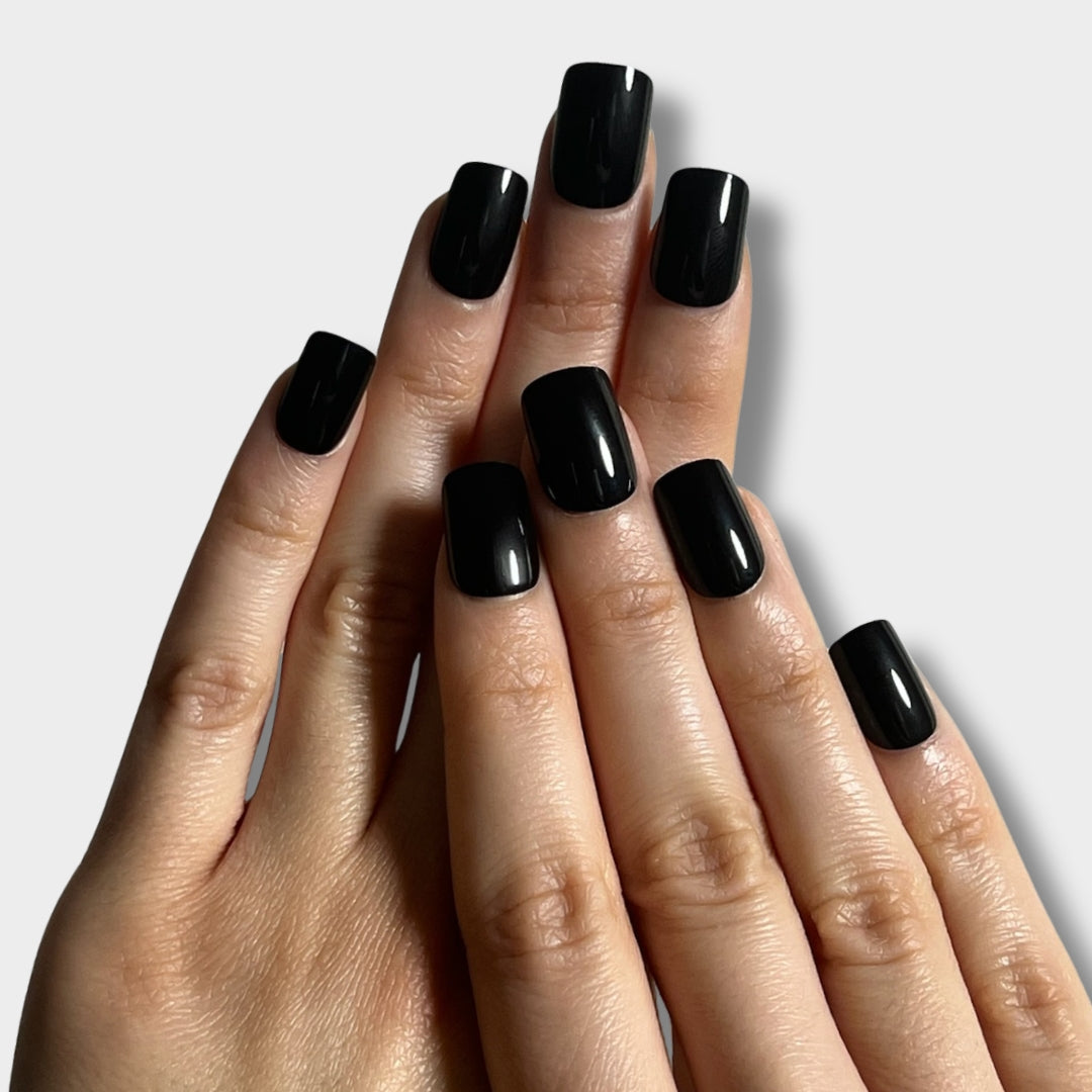Glossy black nail polish bottle from The Instant Nails with a sleek design and vibrant color.